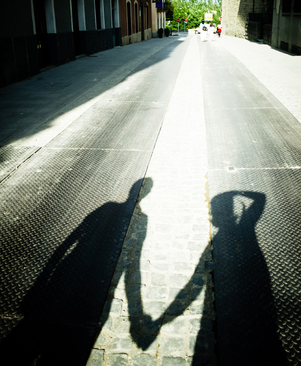 Shadow of two people holding hands while walking