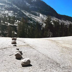 A line of small rocks marks a path over a boulder.